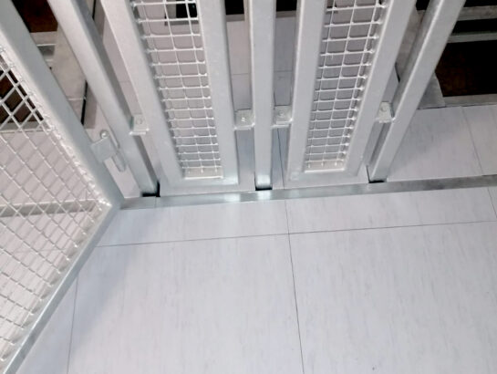 Maßgeschneiderte, verzinkte Stahlgitter-Trennwand und Absturzsicherung für einen Schaltwartenboden von MM Doppelboden.